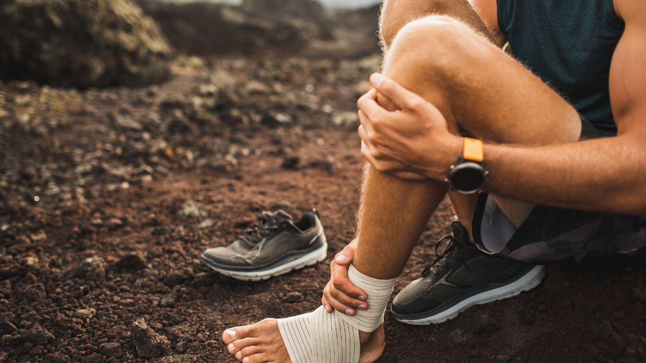 Man bandaging injured ankle